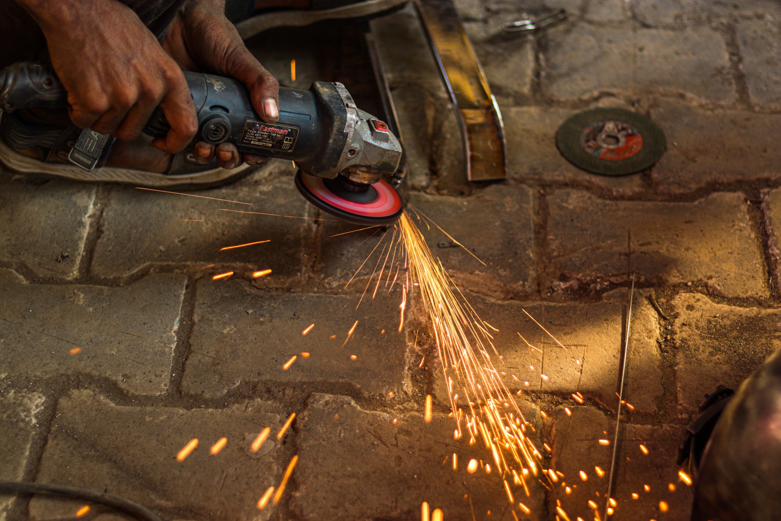 Close-up of a skilled worker using a grinder on metal, creating sparks.